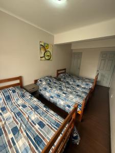 a room with two beds and a door at Hostal Matta in Antofagasta