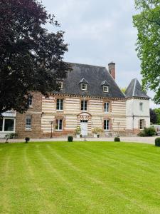 a large brick house with a large grass yard at Maison Nolette - Chambres & Table d'hôtes in Noyelles-sur-Mer