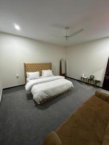 a bedroom with a large bed and a couch at Hotel comfort hill in Abbottabad
