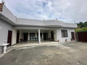 a white house with a porch with blue chairs at Hotel comfort hill in Abbottabad +11 photos