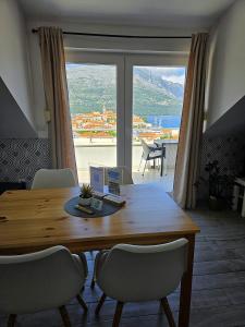 a dining room table with chairs and a large window at Adriatic Pearl Korcula in Korčula