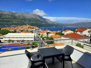 a balcony with a table and chairs and a city at Adriatic Pearl Korcula in Korčula