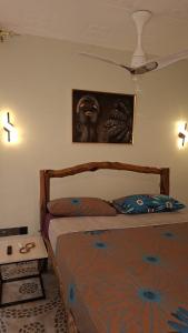 a bedroom with a bed and a painting on the wall at Amerix resorts and adventures in Diani Beach
