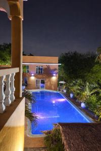 a swimming pool in front of a house at night at Amerix resorts and adventures in Diani Beach