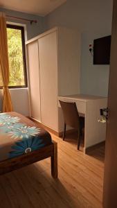 a bedroom with a bed and a table and a window at Amerix resorts and adventures in Diani Beach