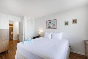 a white bedroom with a large white bed in it at Ilikai Marina 1394 in Honolulu +10 photos