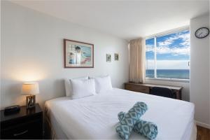 a bedroom with a bed with a view of the ocean at Ilikai Marina 1394 in Honolulu