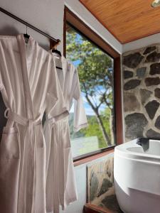 a robe hanging on a wall next to a window at Rainbow Valley Lodge Costa Rica in Monteverde Costa Rica +152 photos