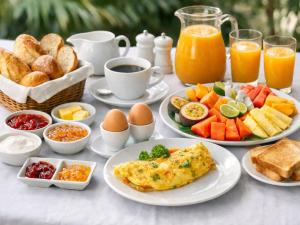 a table topped with plates of breakfast foods and orange juice at Villa Bossi Bali at Tanguwesia in Bubunan