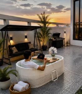 a man sitting in a bath tub on a patio at Orchid Villa salalah in Salalah