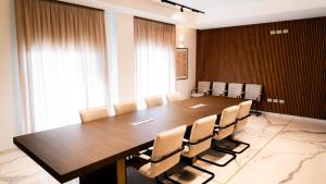 a conference room with a large wooden table and chairs at TubHotel in Grottazzolina
