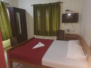 a bedroom with a bed and a television in it at S P Nettoor in Cochin +7 photos