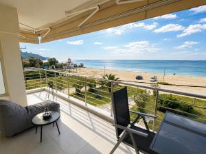 a room with a balcony with a view of the beach at Sea View Luxury Apartment Beachfront 3BR in Agia Triada