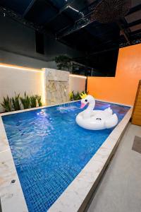 a pool with an inflatable swan in the middle at Olive SamSon Hotel in Sầm Sơn