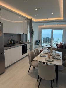 a kitchen and living room with a table and chairs at Sea View Luxury Apartment Beachfront 3BR in Agia Triada
