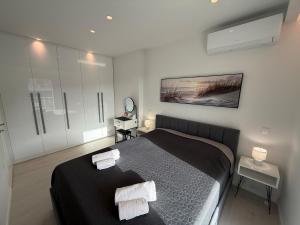 a bedroom with a bed with two towels on it at Sea View Luxury Apartment Beachfront 3BR in Agia Triada