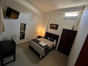 a bedroom with a bed and a television in it at Hotel Estancia Real in Piura