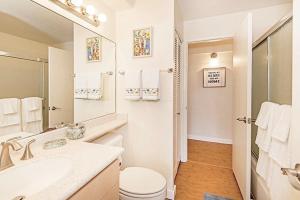 a white bathroom with a sink and a toilet at Discovery Bay 1419 in Honolulu +8 photos