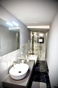 a bathroom with a white sink and a shower at Suite Romantica con Jacuzzi e Sauna in Porto Empedocle +9 photos