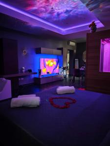 a living room with two beds and a large screen tv at Suite Romantica con Jacuzzi e Sauna in Porto Empedocle