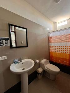 a bathroom with a sink and a toilet and a mirror at Hotel Estancia Real in Piura +57 photos