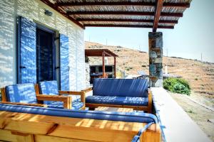a porch with blue chairs on a house at Delta Villa's Kythnos II in Kithnos