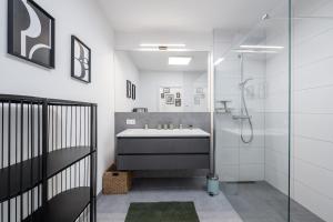 a white bathroom with a sink and a shower at Wiesenblick Residences - by myNests in Haus im Ennstal +116 photos