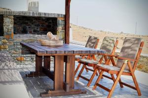 a wooden table and chairs on a patio at Delta Villa's Kythnos II in Kithnos +19 photos
