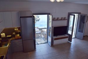 a kitchen with two sliding doors and a television at Delta Villa's Kythnos II in Kithnos
