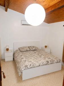 a white bedroom with a bed and a large light at Les Mûriers in La Ciotat