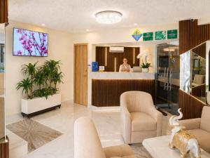 a lobby of a dermatologist office with a woman in the background at Hotel Aikos in Yumbo