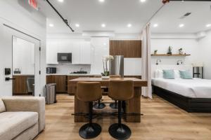 a bedroom and living room with a bed and a table and chairs at SympleLive Hotel in Boston