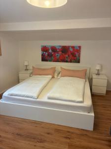 a bedroom with a large white bed with two night stands at Ferienwohnung Diwoky in Sankt Gilgen