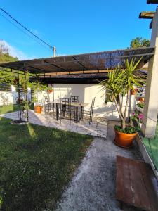 a patio with a table and chairs under a pergola at Tara Lapčići Budva in Budva