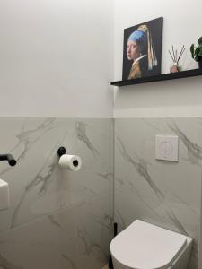 a bathroom with a toilet and a picture of a woman at Bedroom Dordrecht Centrum - La Focaccina in Dordrecht
