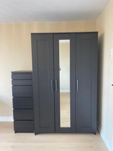 a large black wardrobe in a room with a mirror at Bedroom Dordrecht Centrum - La Focaccina in Dordrecht