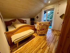 a bedroom with a bed and a chair and a window at Pension Sonnenheim in Winterberg