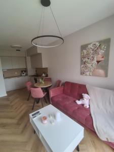 a living room with a red couch and a table at Baltic Porto M66 in Gdańsk +3 photos