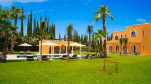 an orange house with a yard with a goal at Luxury villa in Azib Oulad Lâdem