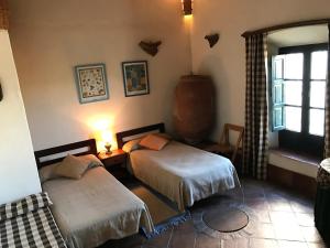 a bedroom with two beds and a window at Cortijo Viña del Duco in Azuaga