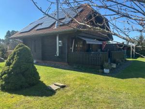 a wooden house with a porch and a yard at Ferienhaus Evelin in Keune