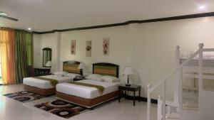 a bedroom with two beds and a staircase at Ongville Hotel & Events Place in Candelaria