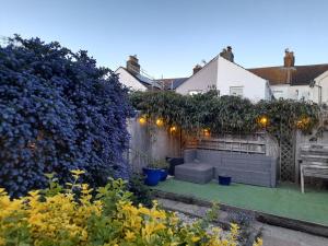 a garden with a bench and a fence at Kingfisher cottage, free parking in Worthing