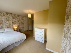 a bedroom with a white bed and a dresser and a bed sqor at An Teach Ban in Tralee