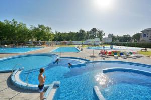 a man standing in a large swimming pool at Akvamarin Downtown Apartman in Székesfehérvár