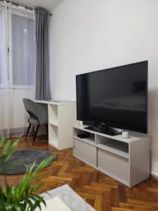 a living room with a flat screen tv on a white entertainment center at Akvamarin Downtown Apartman in Székesfehérvár