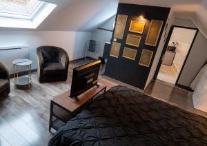 a room with a bed and a tv and a chair at Chez Cathy et Sébastien in Illies +25 photos