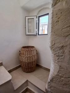 a wicker basket sitting next to a wall with a window at Maison della Madia in Triggiano