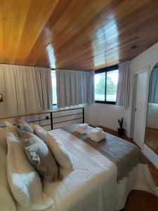 a bedroom with a large white bed with pillows at Rincon de Luna, Cabañas in Mar del Plata