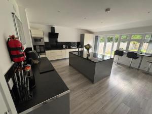 a large kitchen with black counter tops and appliances at Kane's Place in Birkenhead